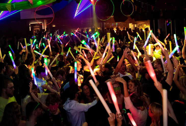 Crowd of students with glowsticks at nightclub freshers party